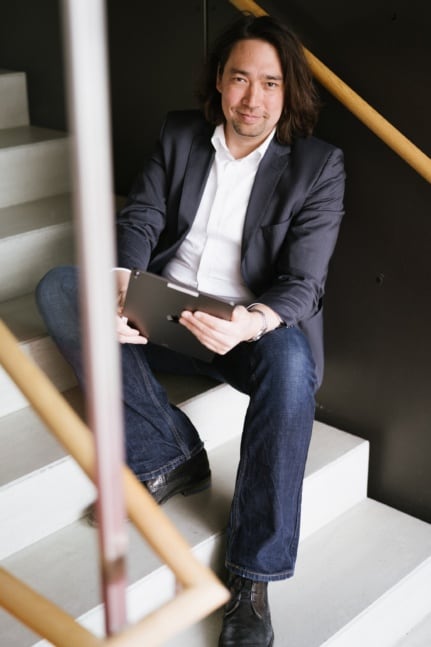 Ein Anwalt sitzt auf einer Treppe mit einem Tablet