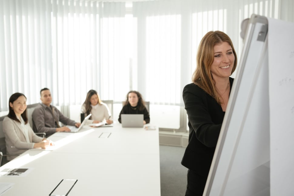 Anwälte haben eine Besprechung, eine Frau steht an einem Flipchart