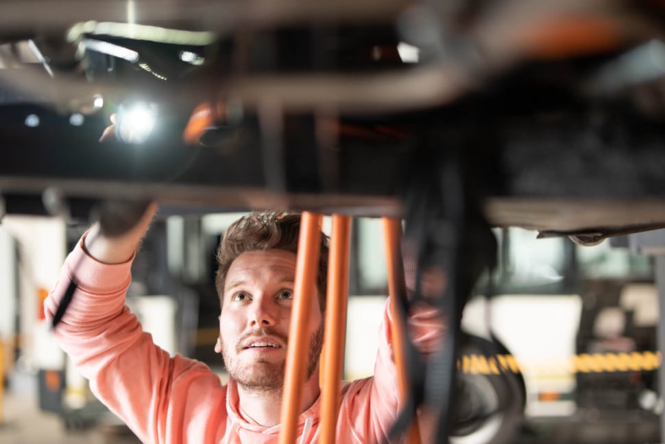 Ein Mechaniker schraubt unter einem Auto