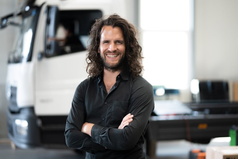 Ein Mechaniker mit verschränkten Armen vor einem LKW