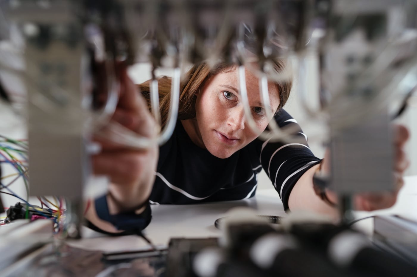 Eine Ingenieurin verkabelt ein technisches Gerät