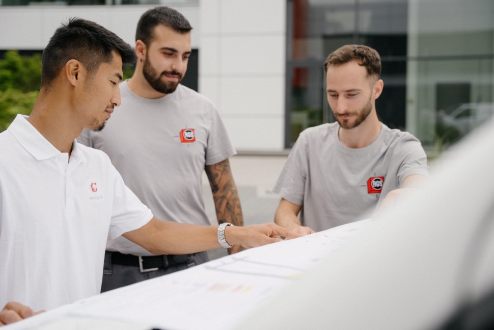Drei Kollegen von RGS Technischer Service besprechen Pläne für eine Klimamontage